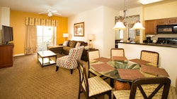 The interior of a hotel room with furnished dining and living areas